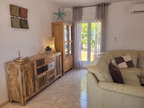 Un salon avec un meuble en bois, un canapé beige et une décoration en forme d’étoile de mer.