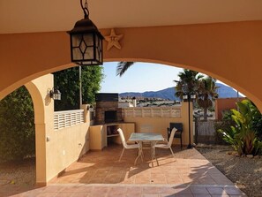 Un patio exterior con mesa y sillas, una parrilla y una decoración con forma de estrella.