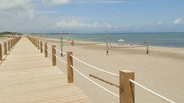 A wooden boardwalk leading to a sandy beach with a clear sky. - AP ECODUNES, Ideal house for your holidays near the sea, free wifi, optional air conditioning, community pool, pets allowed, dog’s beach (Delta de l'ebre)