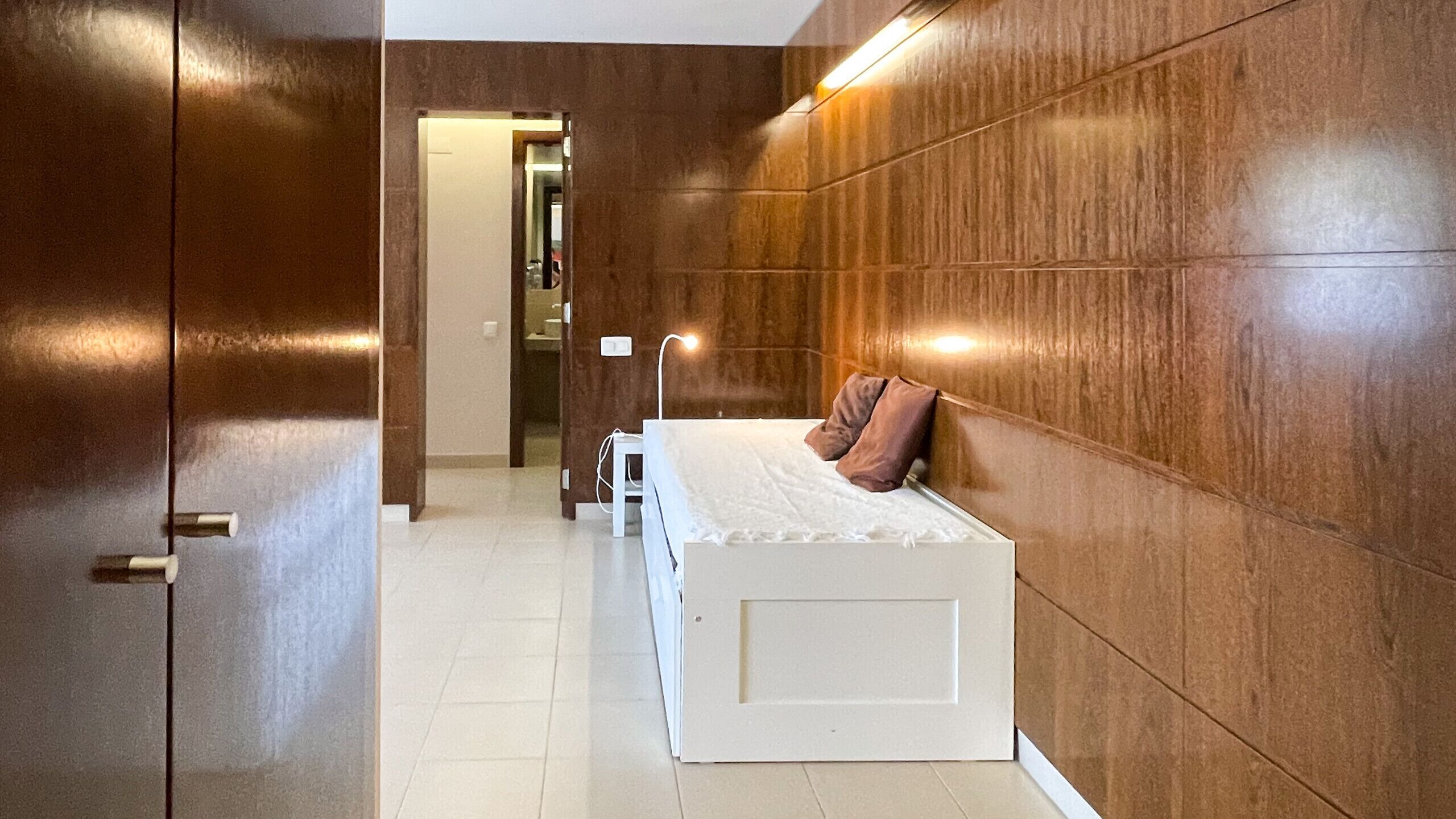 A bedroom with a bed, a bedside table, and a nightstand.