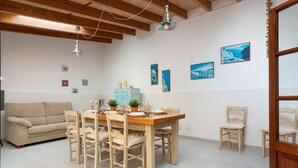 A dining area with a wooden table and chairs, a sofa, and wall art. - CAN TONI,  Apartment, 100 m from the white sand beach, for 6 People (Alcúdia)