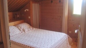A single bed in a room with wooden walls and a sloped ceiling. - Chalet - CHORGES (Chorges)