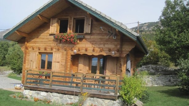A wooden cabin with a balcony, stone foundation, and a mountainous backdrop. - Chalet - CHORGES (Chorges)