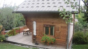 A wooden cabin with a porch, a table, and a chair. - Chalet - CHORGES (Chorges)