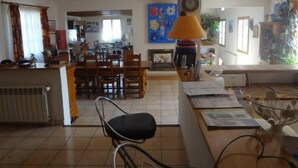 A spacious living area with a dining table, chairs, a sofa, and a lamp. - Large 200m² house with swimming pool (5 by10m) near Alès in the Cévennes, 8people (Laval Pradel)