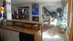 A spacious living area with a kitchen, dining table, and a staircase leading to an upper floor. - Large 200m² house with swimming pool (5 by10m) near Alès in the Cévennes, 8people (Laval Pradel)