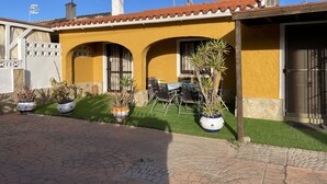 A yellow building with a tiled roof, outdoor seating, and potted plants. - Detached villa with swimming pool (Dénia)
