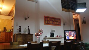Ein Essbereich mit Holzmöbeln, einem Fernseher und Wanddekorationen.