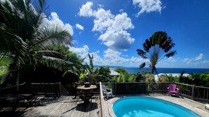 A wooden deck with a pool, surrounded by tropical plants and a view of the ocean. - Blue Diamond Paradise A little corner of paradise with a breathtaking sea view (diamant)