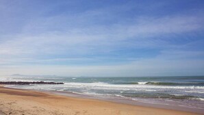 Une plage avec des vagues et un ciel dégagé.
