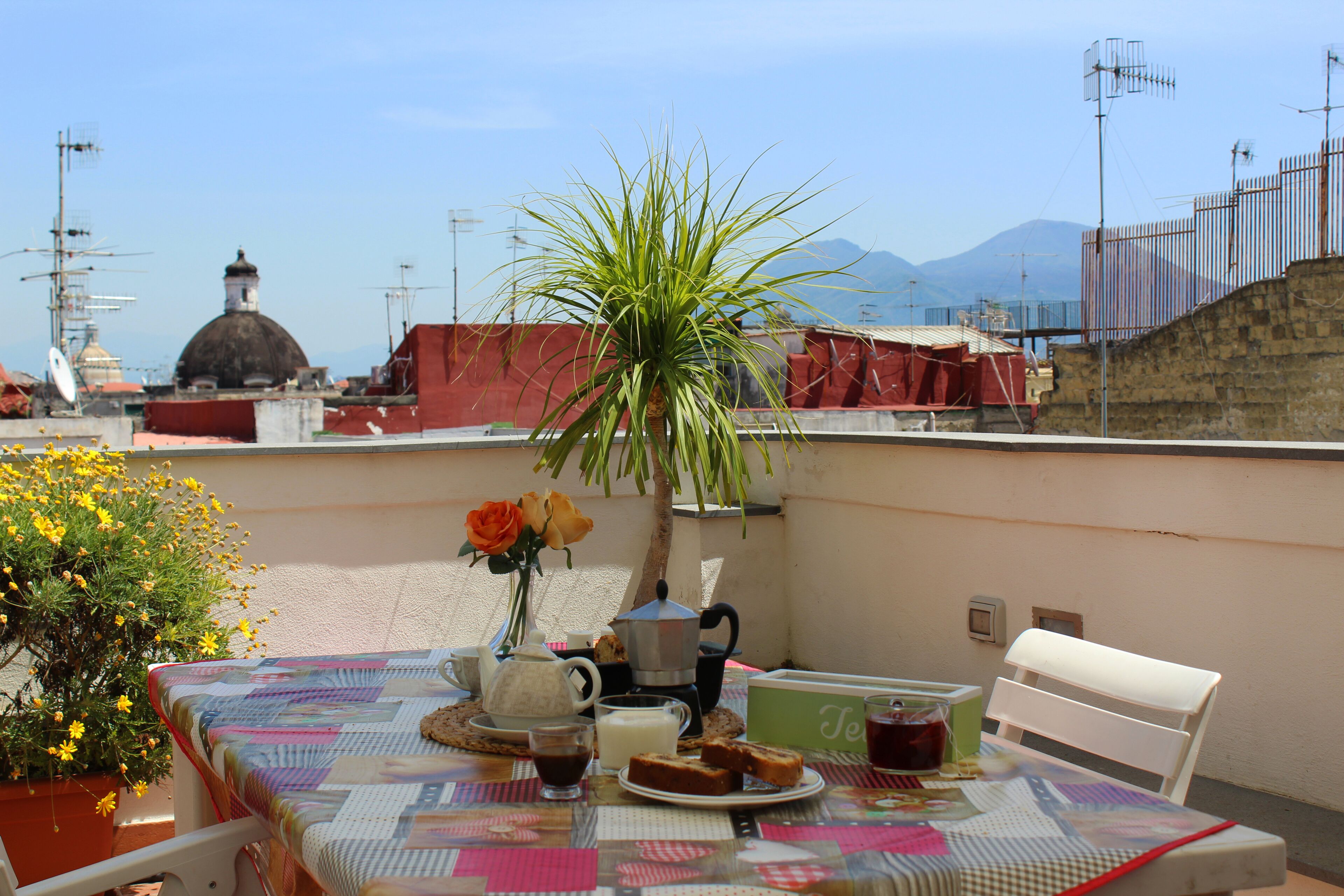 A table set for breakfast with a view of mountains and a dome structure in the background.