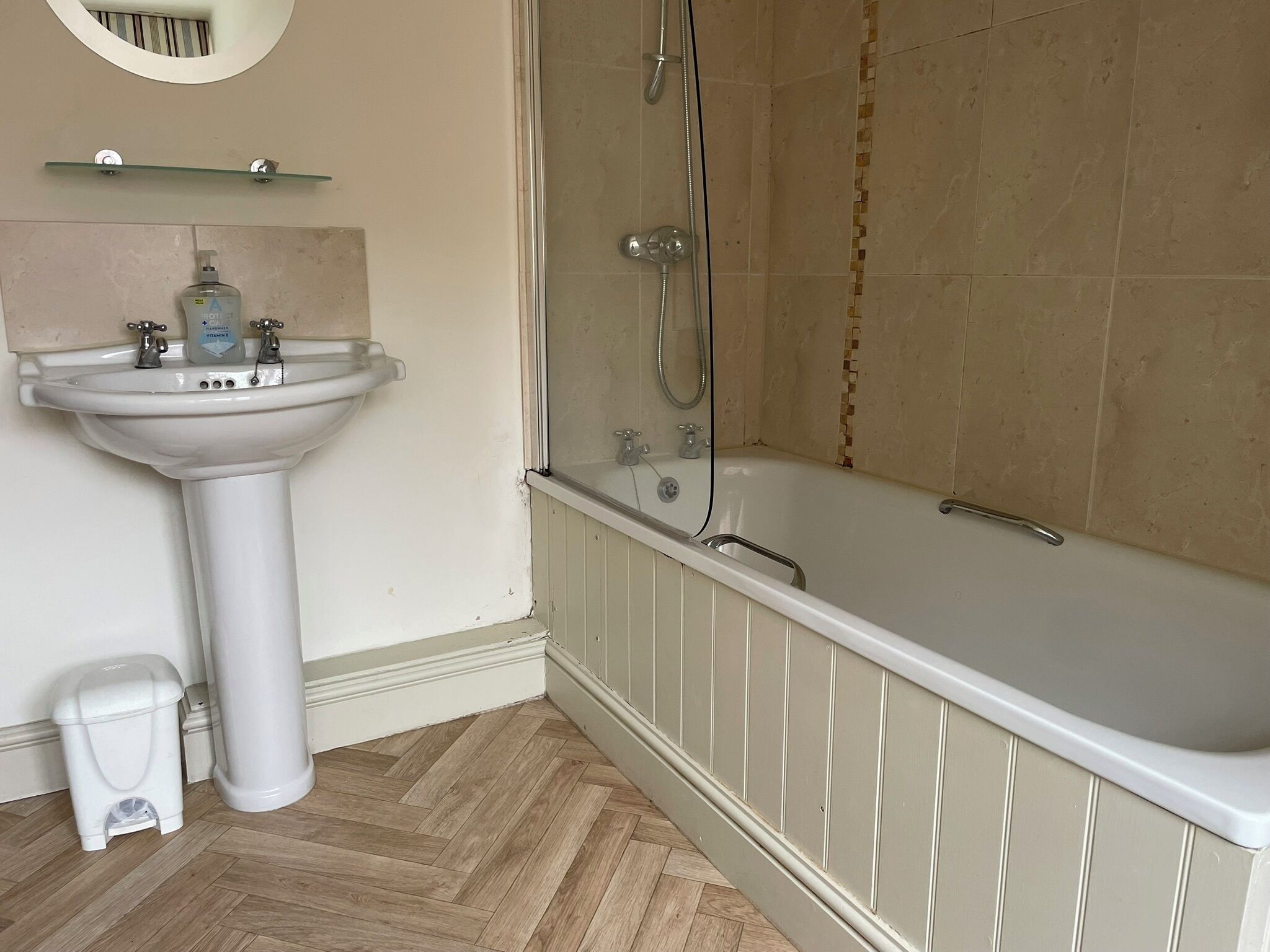 A bathroom with a pedestal sink, a bathtub, and a shower.