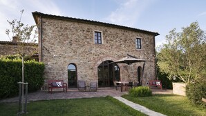 A stone building with an outdoor seating area, including tables and chairs, and a pathway leading to the entrance. - La Casetta, Casole d'Elsa, Siena. Join the real Tuscany countryside! (casole d'elsa siena)