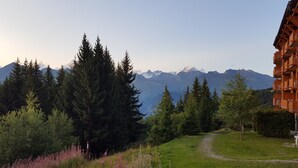 Une vue sur la montagne avec un sentier menant à un bâtiment doté de balcons.