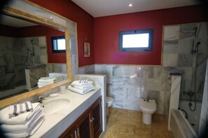Een bad/douchecombinatie, een haardroger, een bidet, handdoeken