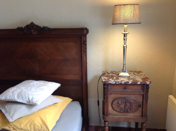 A wooden bed with a headboard, a bedside table with a lamp, and a pillow. - House / Villa - VILLENY (Villeny)