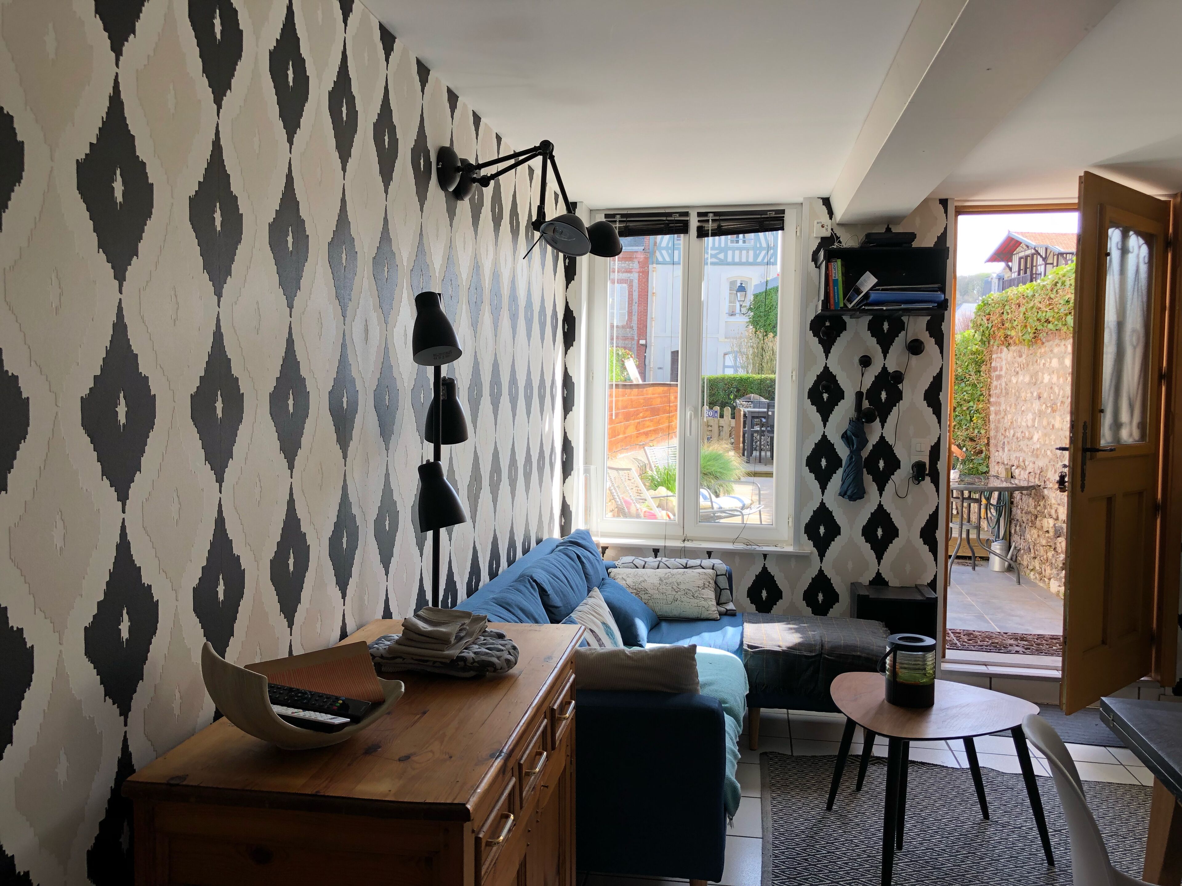 Uma sala de estar acolhedora com sofá, mesa de madeira e janela com vista para o exterior.