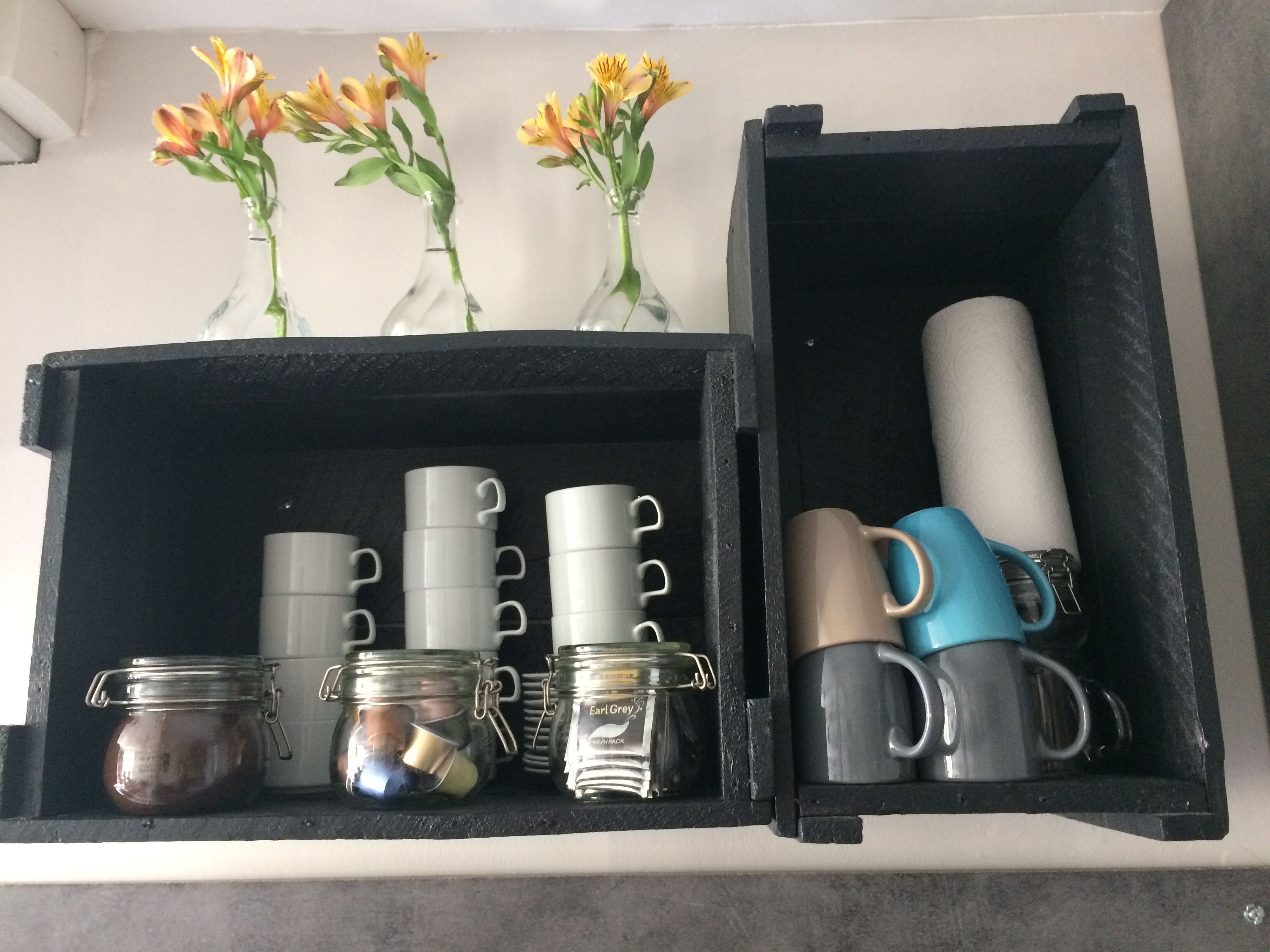 Una caja negra con frascos, tazas y jarrones.