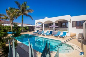 Een buitenzwembad, een verwarmd zwembad en ligstoelen