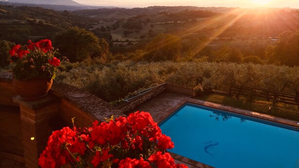 Uma piscina com vista para um vale e montanhas ao fundo.