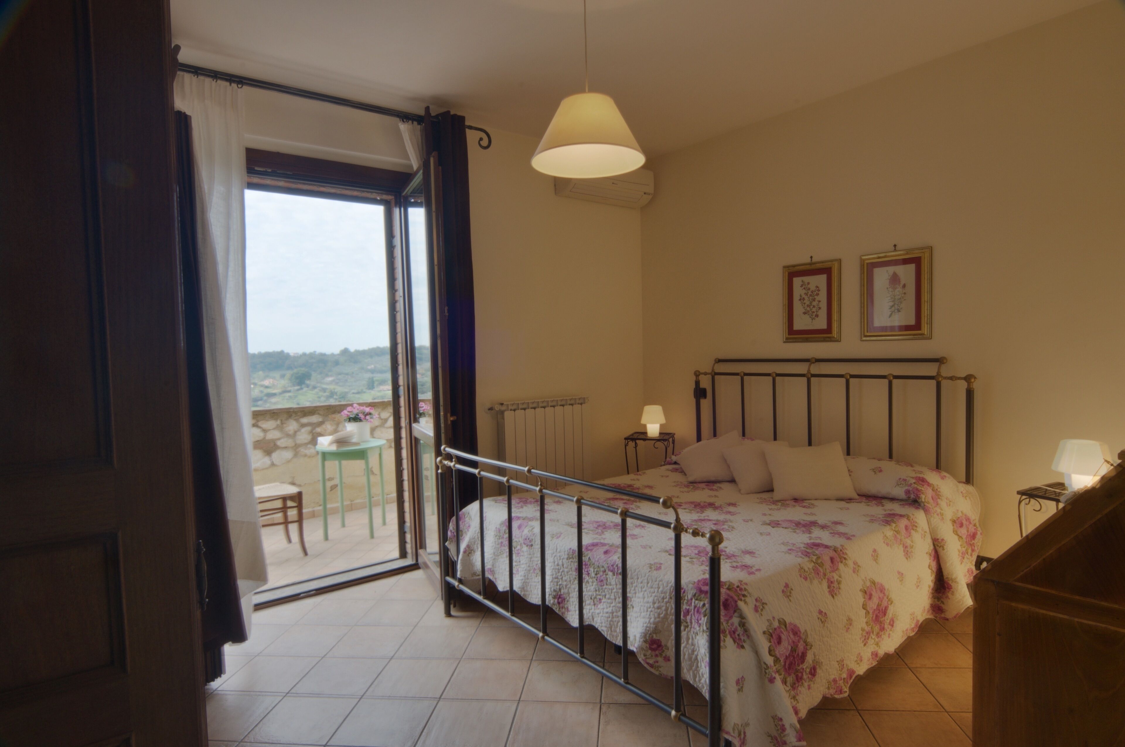 A bedroom with a bed, a window, a table, and a chair.
