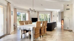 A spacious dining area with a table, chairs, and a television. - Sea view. Swimming pool 8x4m. Very quiet location. 150m2 (Fréjus)