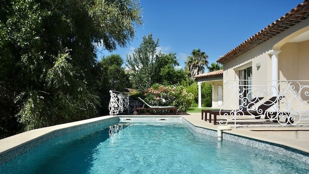 A swimming pool with a tiled edge, surrounded by greenery and a building with a tiled roof. - Sea view. Swimming pool 8x4m. Very quiet location. 150m2 (Fréjus)
