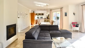 A modern living room with a sectional sofa, a glass coffee table, and a fireplace. - Sea view. Swimming pool 8x4m. Very quiet location. 150m2 (Fréjus)