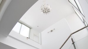 Ein modernes Interieur mit einer Glaskonstruktion als Treppe, einem Oberlicht und einem minimalistischen Design.