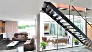 Un salon moderne avec un escalier menant à un espace extérieur.
