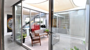 Un intérieur moderne avec des murs en verre, un canapé en bois et un escalier.