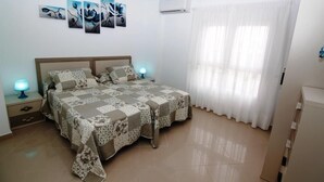 A bedroom with a bed, nightstands, and wall art.