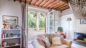 A cozy living room with a sofa, bookshelves, and a TV. - A secret sweet idyllic retreat for 2 couples with private pool & air conditionin (Pieve di Compito)