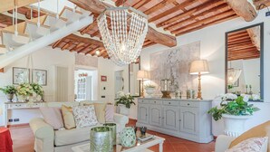 A spacious living room with a high ceiling, a chandelier, a grey cabinet, and a large mirror. - A secret sweet idyllic retreat for 2 couples with private pool & air conditionin (Pieve di Compito)
