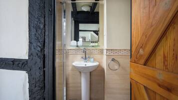 Een bad/douchecombinatie, een haardroger, handdoeken, zeep