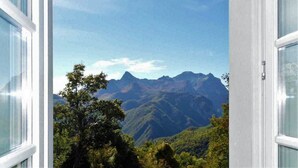 Vista de la montaña a través de una ventana con marcos blancos.