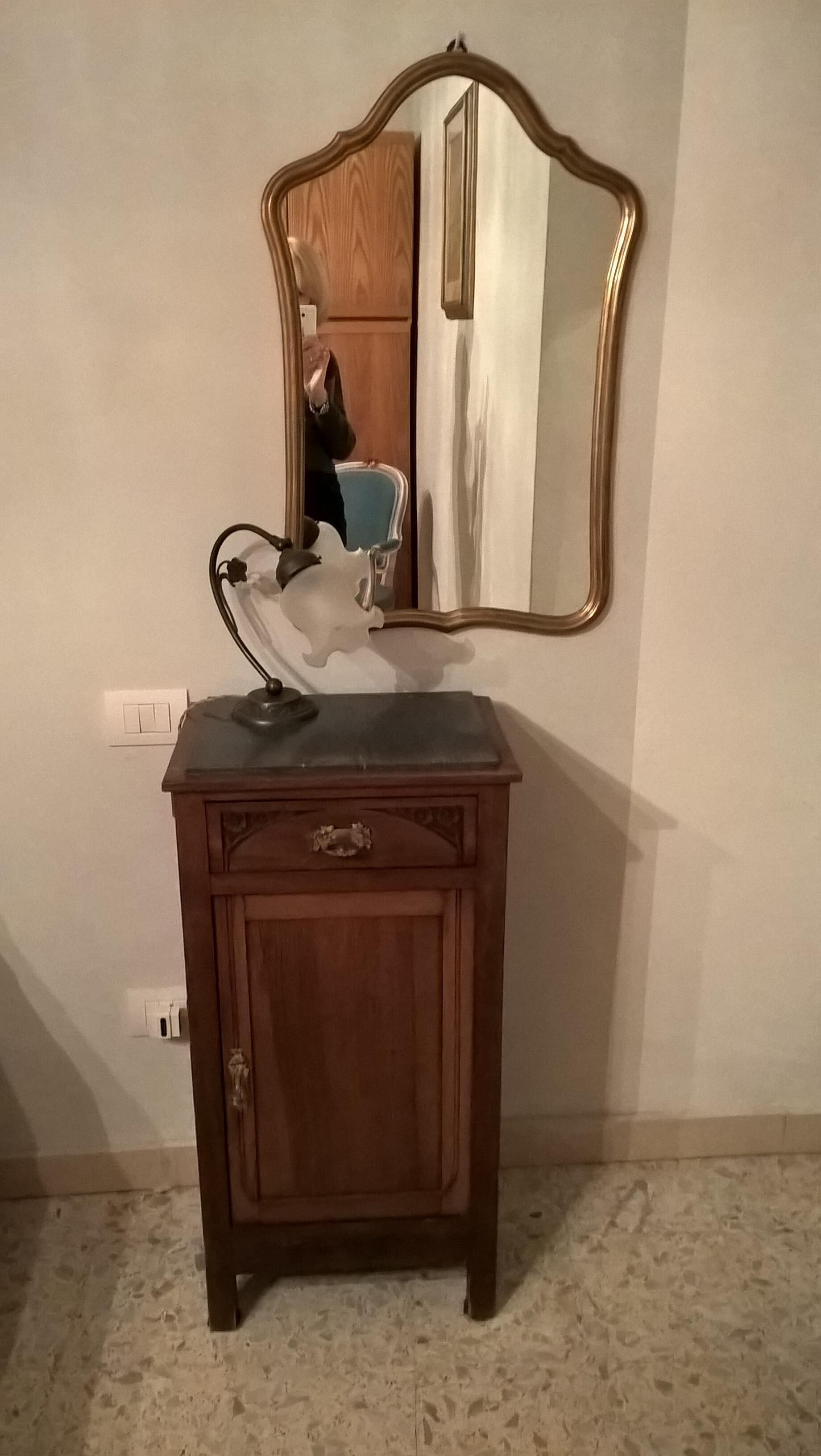 Et trækommode med et spejl og en lampe.