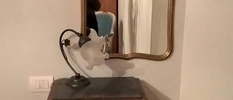 Et trækommode med et spejl og en lampe.