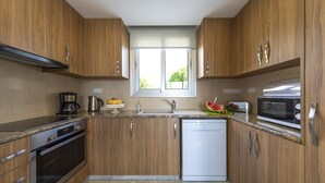 Eine moderne Küche mit Holzausstattung, Backofen, Geschirrspüler und Mikrowelle.
