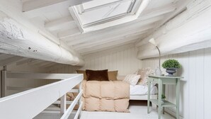A loft bedroom with a bunk bed, a small desk, and a potted plant. - CASA MARGHERITA Stunning view from Terrace (Lucca)