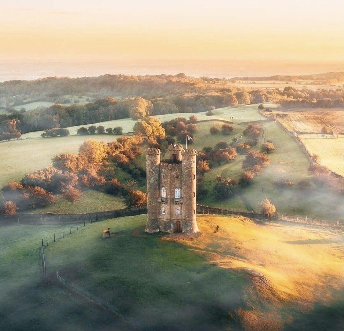 A tower surrounded by rolling hills and fields.