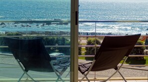 Un balcon avec deux chaises donnant sur la mer.