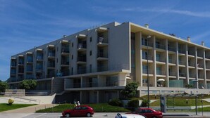 A multi-story hotel with a modern architectural design, featuring balconies on each floor and a central courtyard. - Beach front apartment with superb sea view, 10 min. from Porto   (Vila Nova de Gaia)