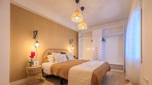 Une chambre à coucher avec un lit, des tables de chevet, une armoire et une fenêtre.