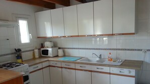 A kitchen with white cabinets, a microwave, a sink, and a gas stove. - Family friendly villa only 5 minutes walk to the Cap d'Agde beach (Richelieu) (Agde)