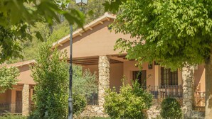 A building with a stone facade, a covered patio area, and a street lamp. - Rural house nº10 for 6 people, Batan Rio Tus (Yeste)