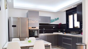 A modern kitchen with stainless steel appliances, a dining table with chairs, and a window with a view. - ☆ Sublime apartment in the heart of Jerusalem ☆ (Jerusalem)