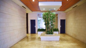 A spacious hallway with a central planter and two doors on either side. - ☆ Sublime apartment in the heart of Jerusalem ☆ (Jerusalem)