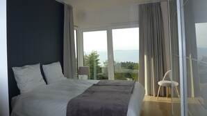 Een slaapkamer met een bed, een stoel en uitzicht op de omgeving.