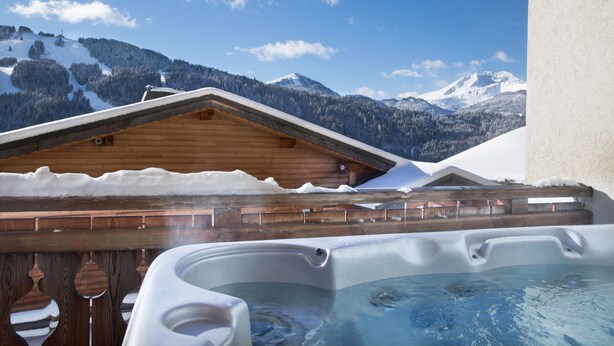 A hot tub area with wooden decking and a view of snow-covered mountains. - Modern 4 bed Chalet, Hot tub, Stunning views of Morzine, easy access to Avoriaz (Morzine)